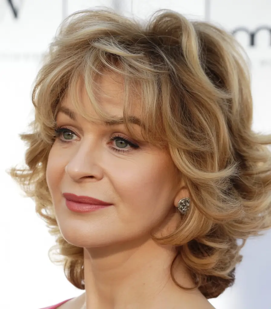 Elegant Fall hairstyles and colors for Women Over 60 in 2025 Golden Curl Revival with Soft Bangs